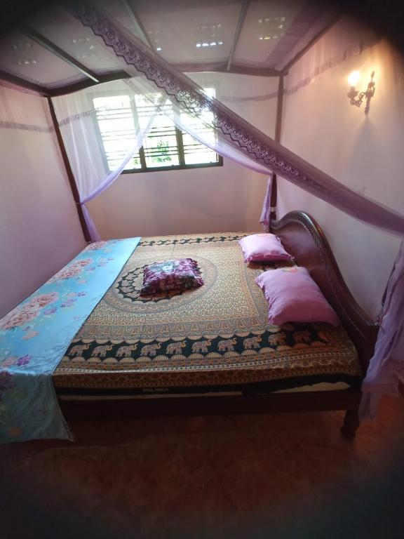 a bedroom with a canopy bed in a room at DAMMI VILLA in Hikkaduwa