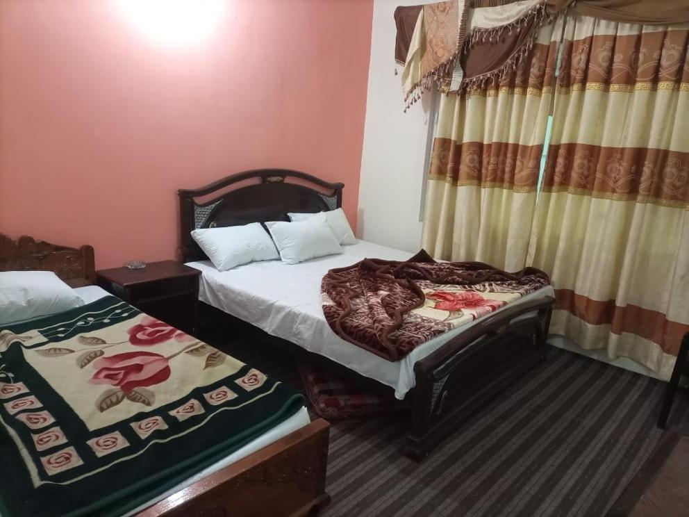 1 dormitorio con 2 camas y ventana en Kaghan Valley Hotel, en Naran