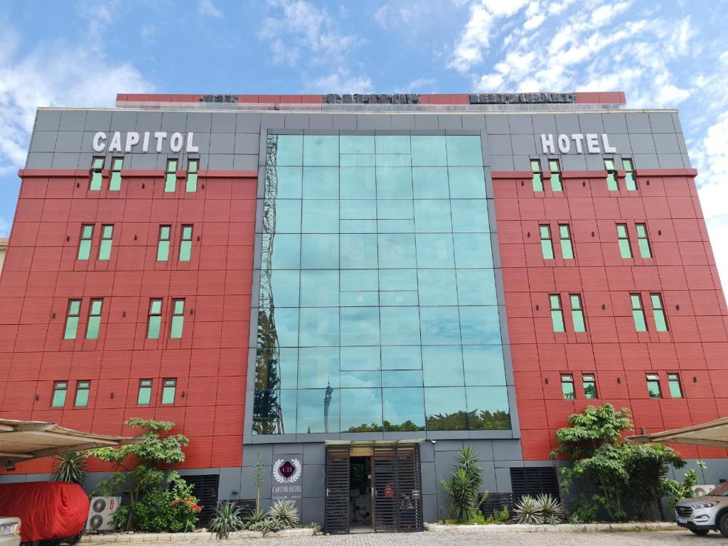 a red hotel with a sign on top of it at Capitole Hotel in Abidjan