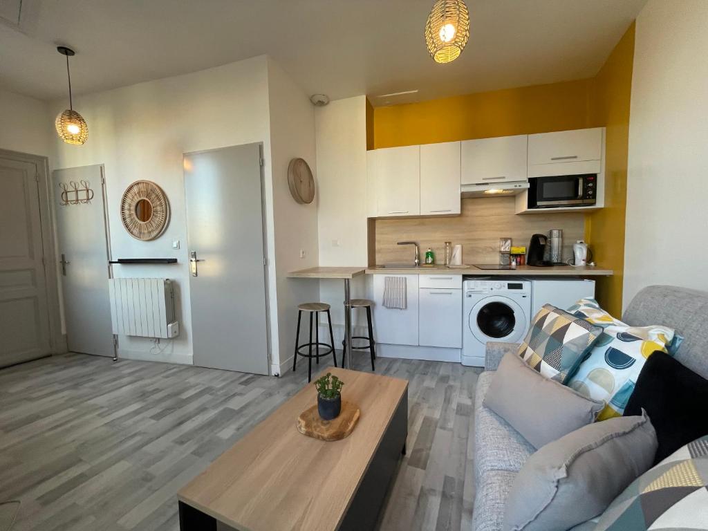 un salon avec un canapé et une table dans l'établissement Studio proche de la gare, à Auxerre