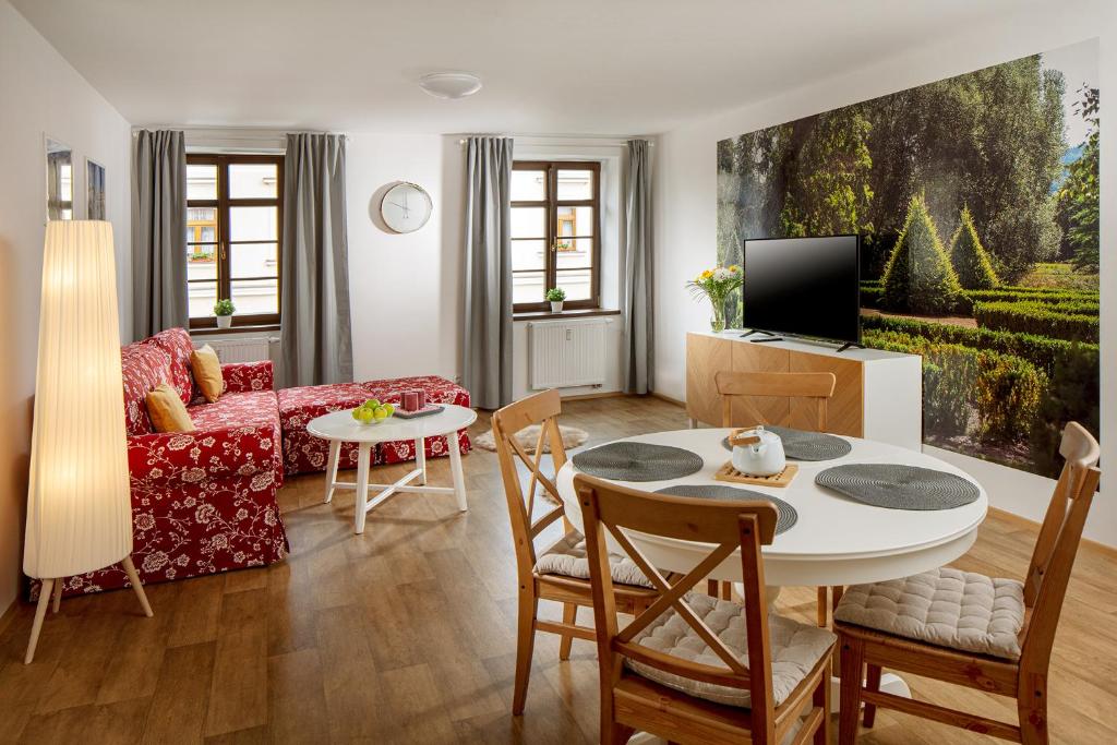 a living room with a table and a couch at Apartmány Myslivna in Ostrov