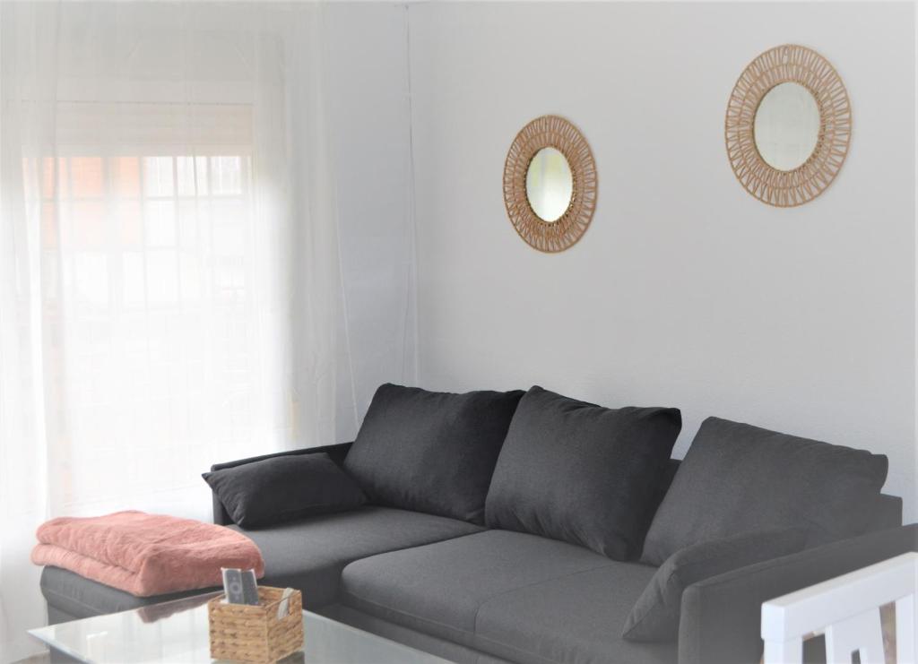 uma sala de estar com um sofá e dois espelhos em La posada Cordobesa em Córdoba