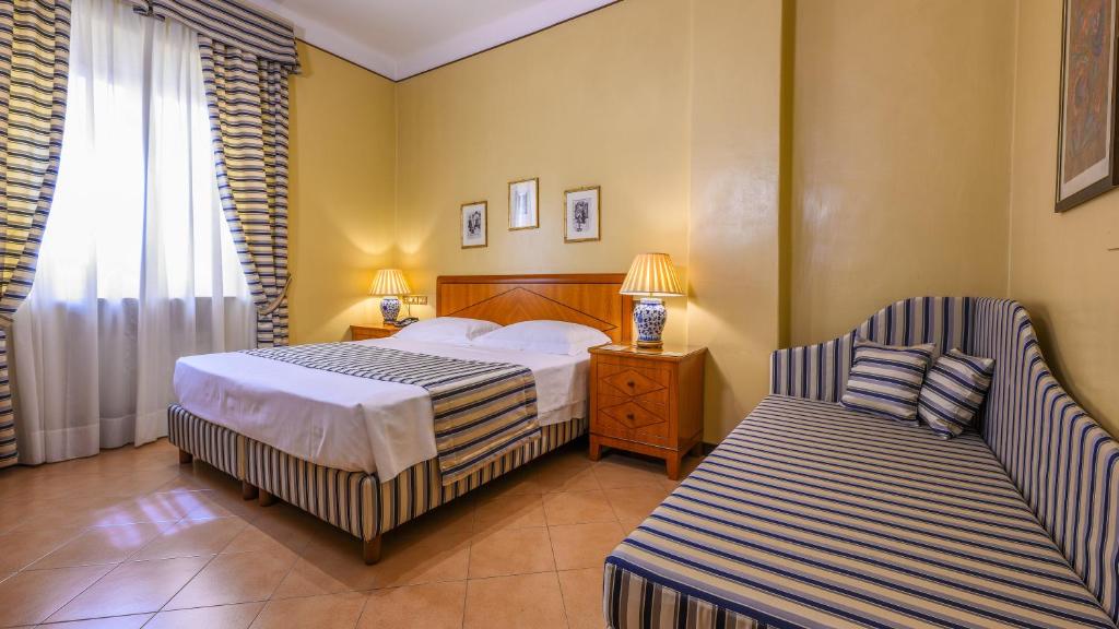 レッジョ・エミリアにあるアルベルゴ レッジョのベッドと椅子付きのホテルルーム