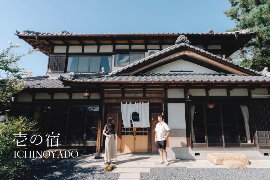 2 personnes debout devant un bâtiment dans l'établissement GUEST HOUSE Ichinoyado - Vacation STAY 39544v, à Tajimi