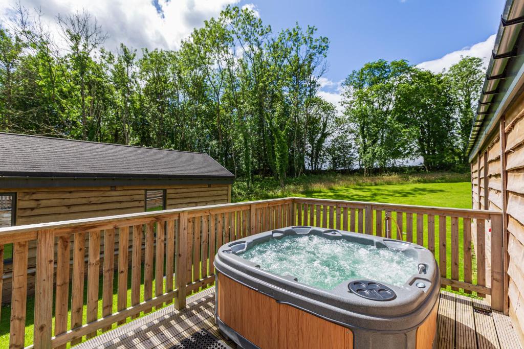 a hot tub on the deck of a house at Squirrel Lodge 43 with Hot Tub in Newton Stewart