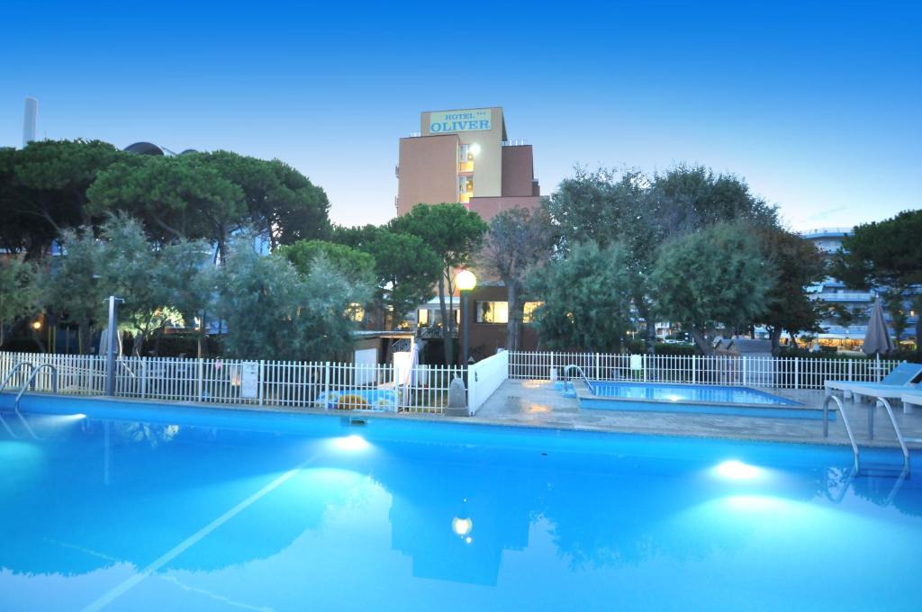 a swimming pool with a building in the background at Hotel Oliver in Caorle