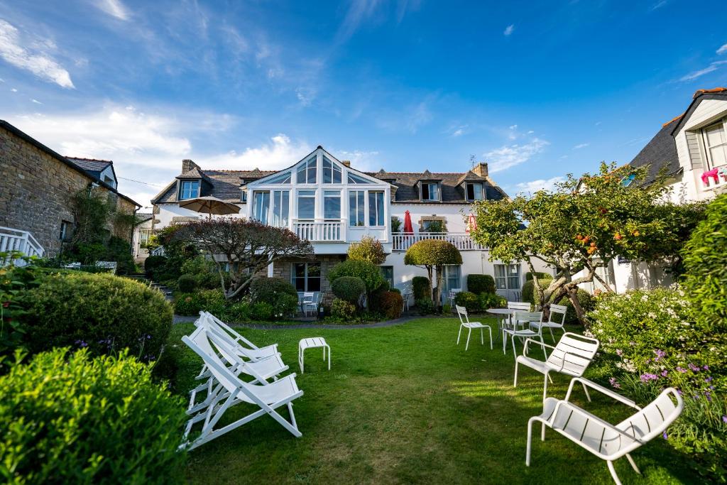 een tuin met witte stoelen en een huis bij Le Lodge Kerisper in La Trinité-sur-Mer