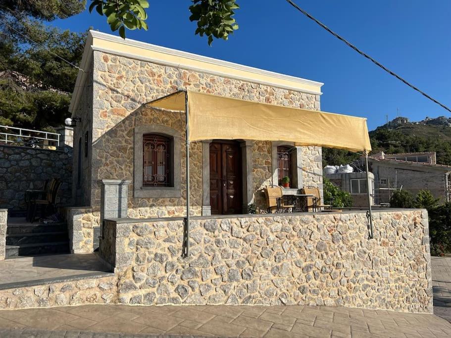 - un petit bâtiment en pierre avec une tente dans l'établissement Panos Renos Studio, a cozy home by the beach!, à Kalymnos