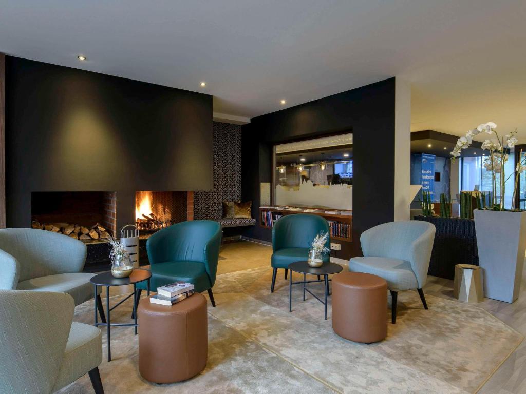 a waiting room with chairs and a fireplace at Mercure Aachen Europaplatz in Aachen