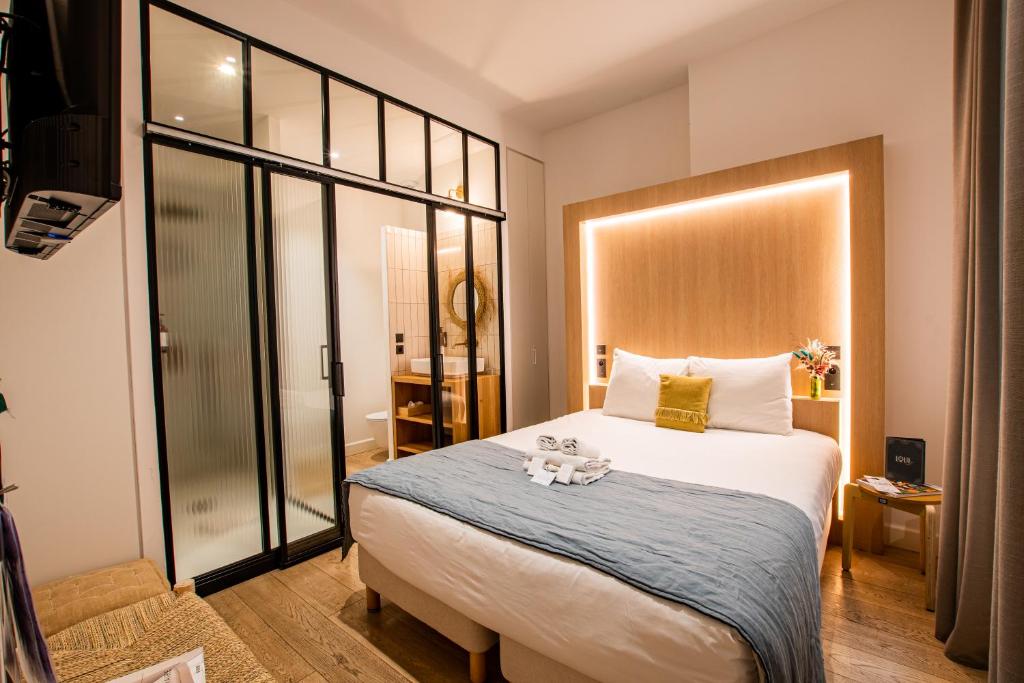 a bedroom with a large bed with a blue blanket at LOLA Boutique Hôtel - Bordeaux Centre in Bordeaux