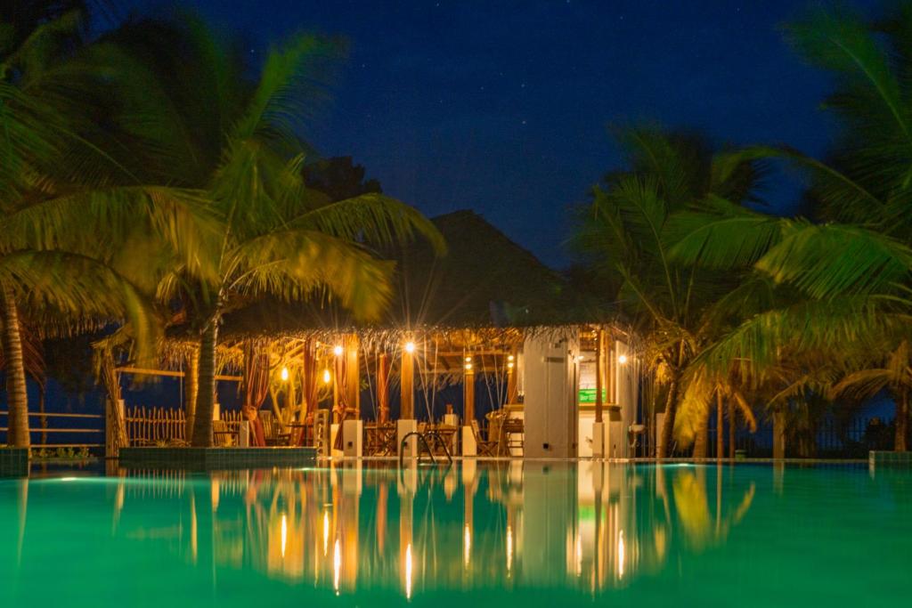 ein Schwimmbad in der Nacht mit einem Resort in der Unterkunft Alai Resort in Mullaittivu