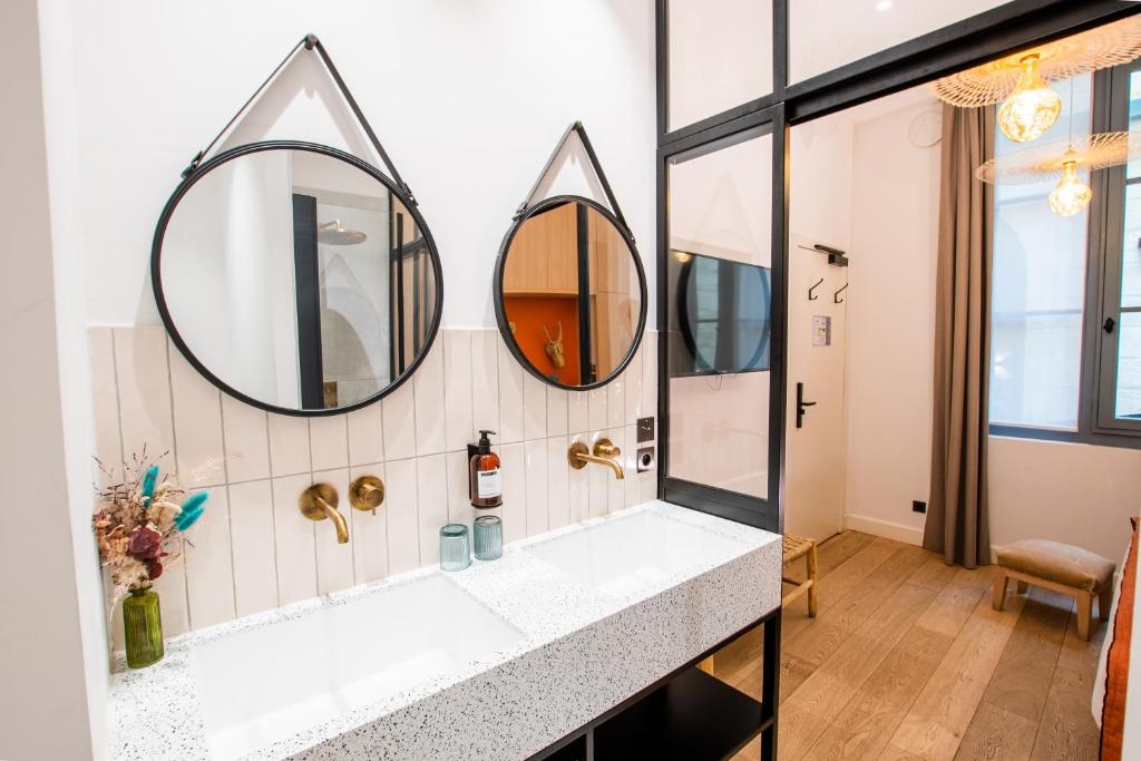 a bathroom with two mirrors and a sink at LOLA Boutique Hôtel - Bordeaux Centre in Bordeaux