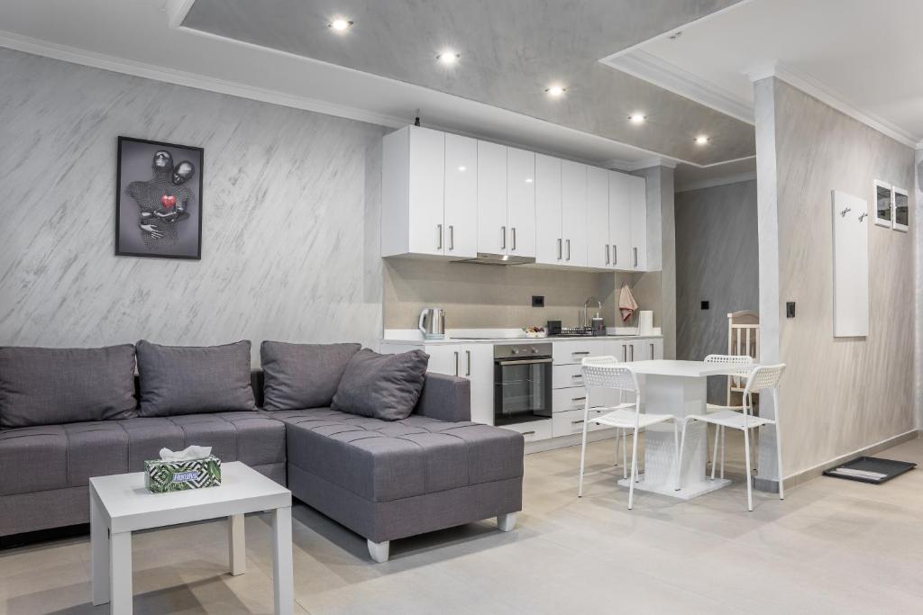 a living room with a couch and a kitchen at JOY APARTMENTS Zemun,Beograd in Zemun