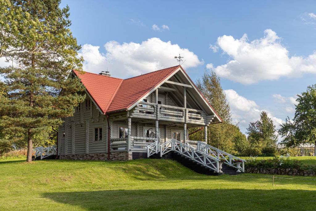 a large wooden house with a red roof at Lillium in Merķeļi
