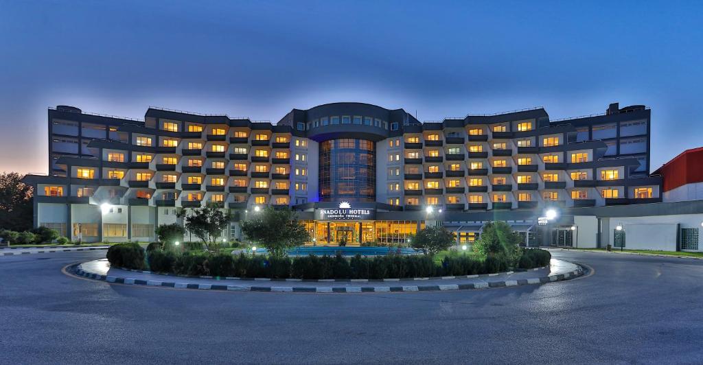 a large hotel building with a courtyard in front of it at Anadolu Hotels Esenboga Thermal in Esenboga