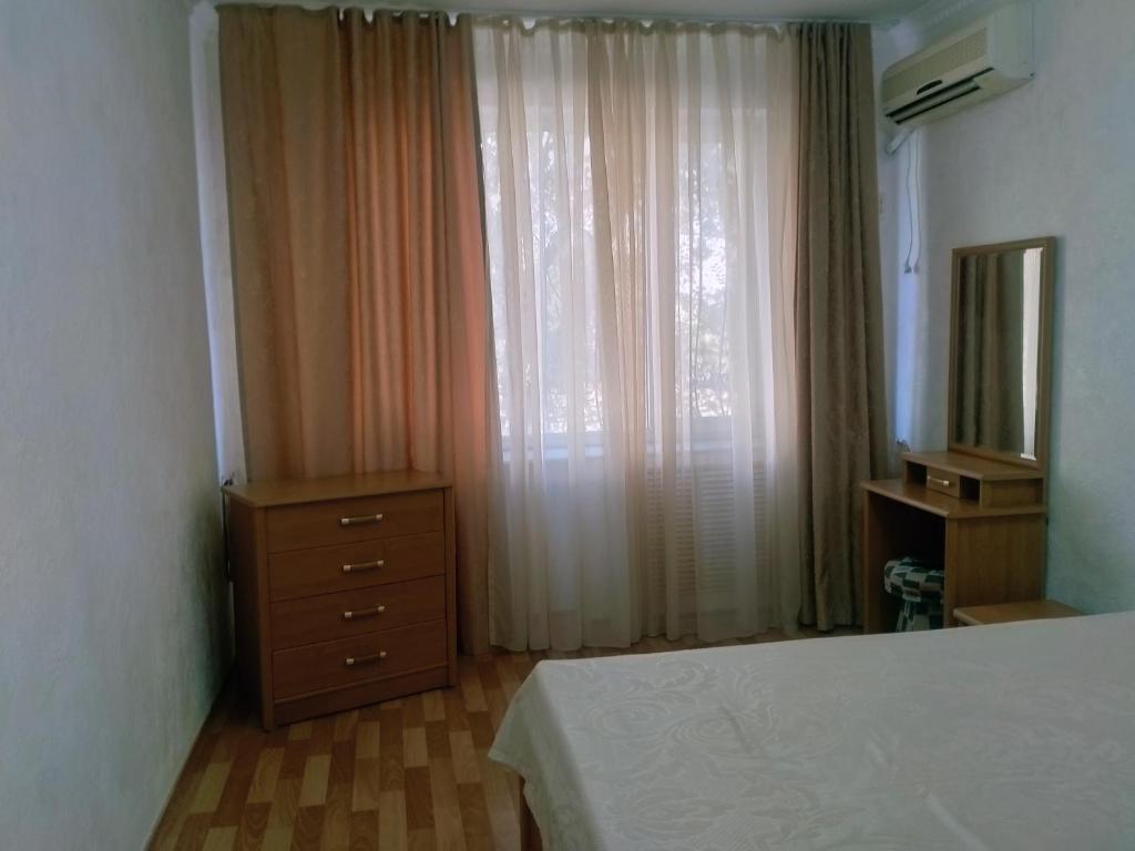 ein Schlafzimmer mit einem Bett, einer Kommode und einem Fenster in der Unterkunft Caspian breeze in Aqtau