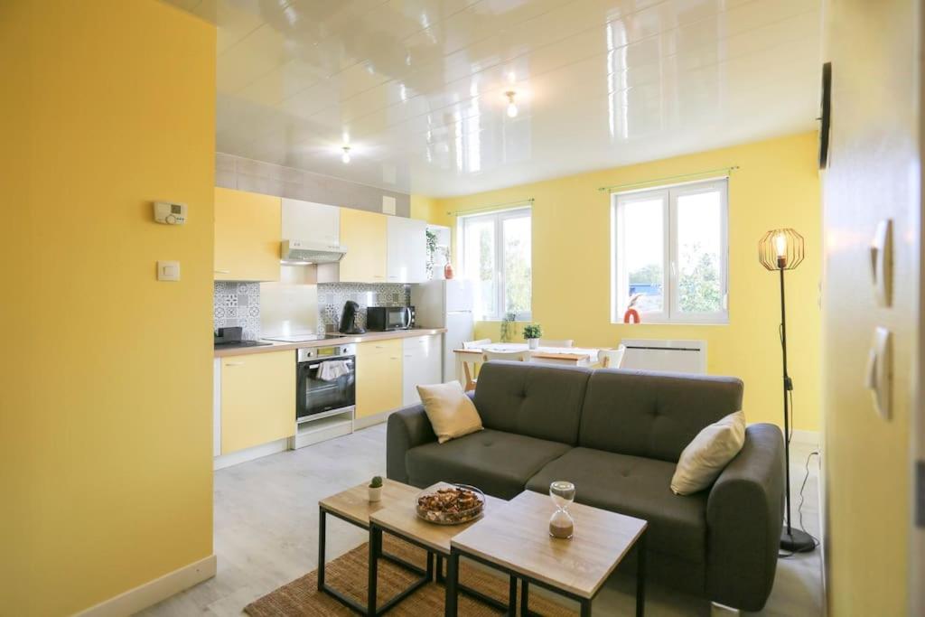 un soggiorno con divano e tavolo di Appartement sans vis-à-vis proche du centre-ville a Douai