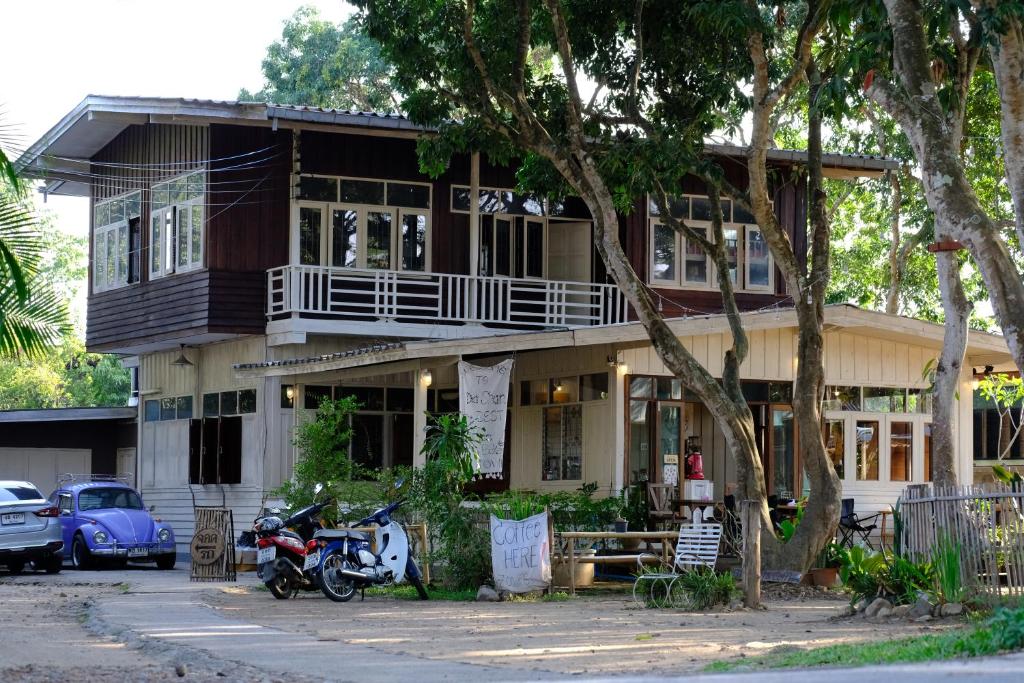 a house with a motorcycle parked in front of it at Yor Song Hostel in Pai