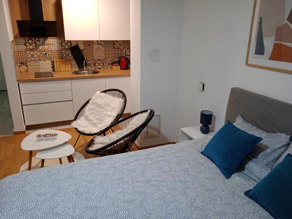 1 dormitorio con 1 cama y 2 sillas y cocina en Studio App Bulevar - free parking, en Sarajevo