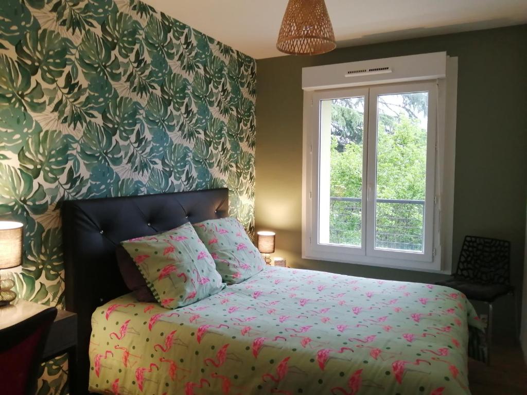 Schlafzimmer mit einem Bett und einem Fenster in der Unterkunft Appartdom in Angoulême