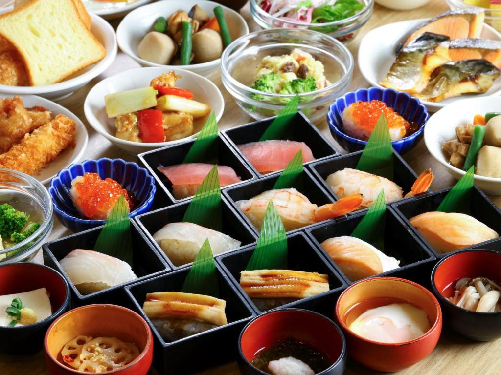 una mesa cubierta con cuencos de diferentes tipos de alimentos en Dormy Inn Tokyo Hatchobori Hot Spring, en Tokio