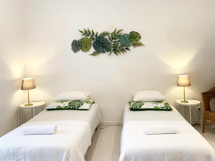 two beds in a room with plants on the wall at Alcântara Studio 15 in Lisbon