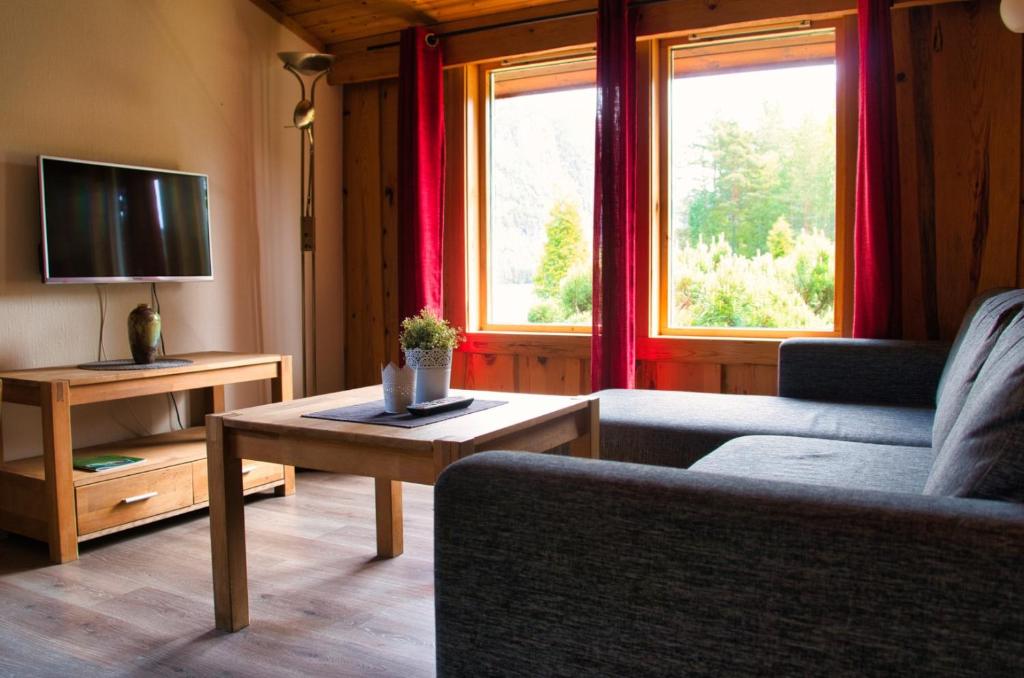 een woonkamer met een bank en een tafel bij Sølvgarden Cottages in Rysstad
