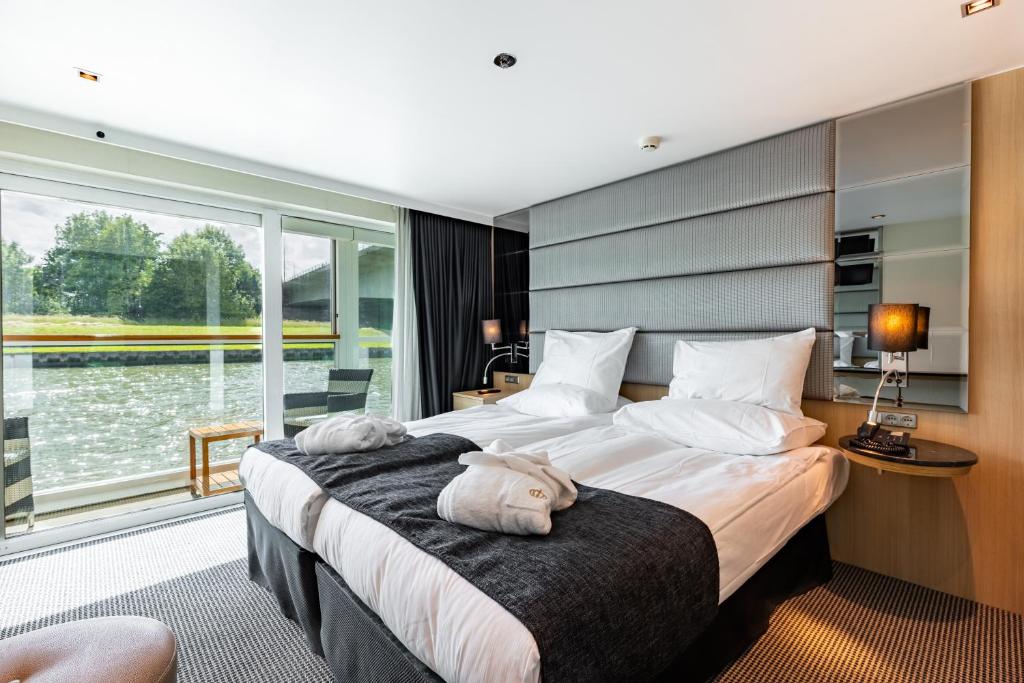 pokój hotelowy z 2 łóżkami i dużym oknem w obiekcie KD Hotelschiff Messe und Stadion w mieście Düsseldorf