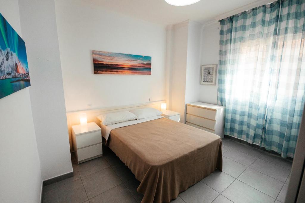 a small bedroom with a bed and two night stands at La puntilla de las canteras in Las Palmas de Gran Canaria