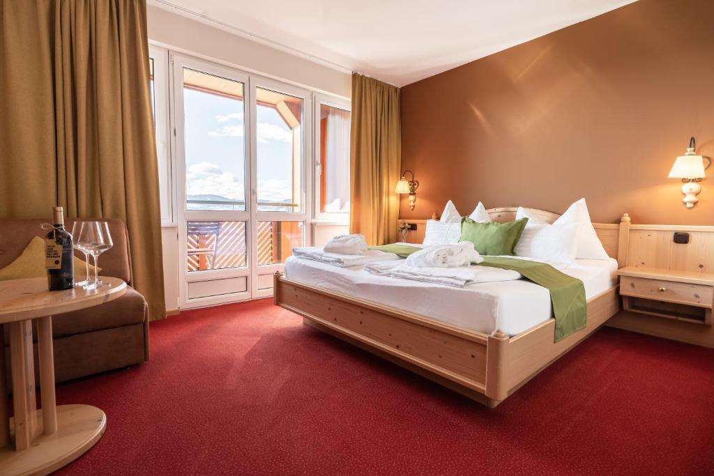 a hotel room with a large bed with a window at Mahorko Wein Wellness Wasserbüffel in Glanz an der Weinstraße 