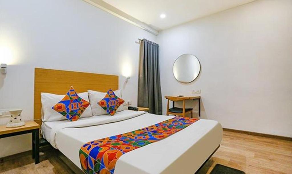 a hotel room with a large bed and a mirror at FabHotel Urban Residency in New Delhi