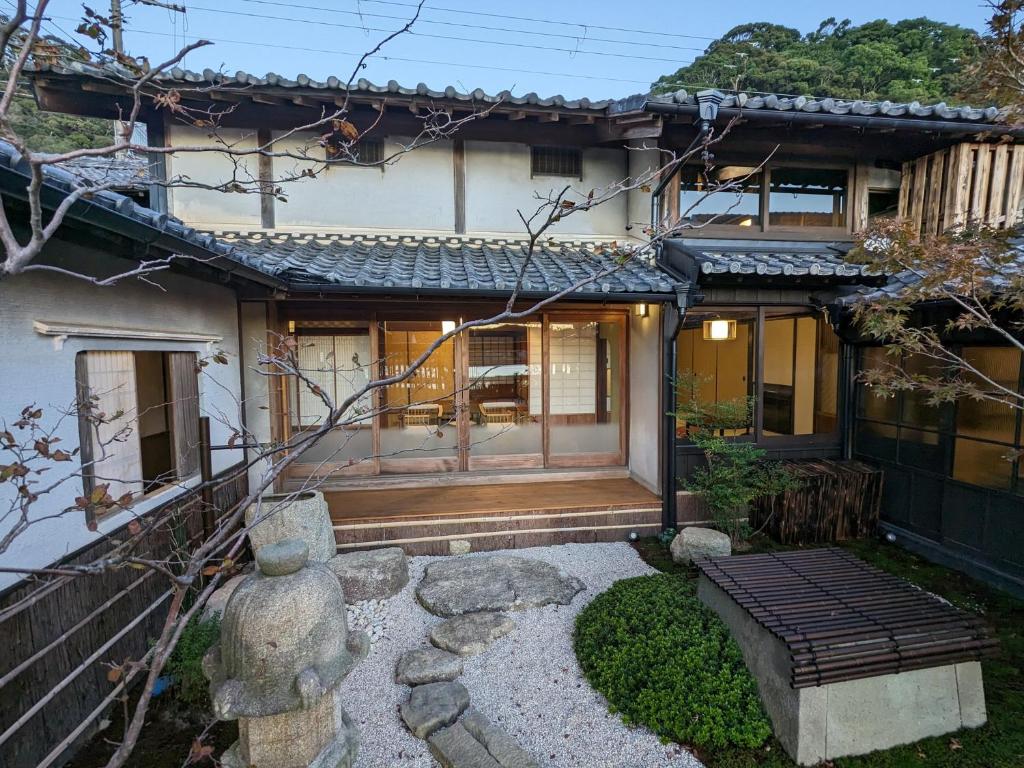 una casa con un camino que conduce a la puerta principal en KOZA River House 湯川邸, en Koza