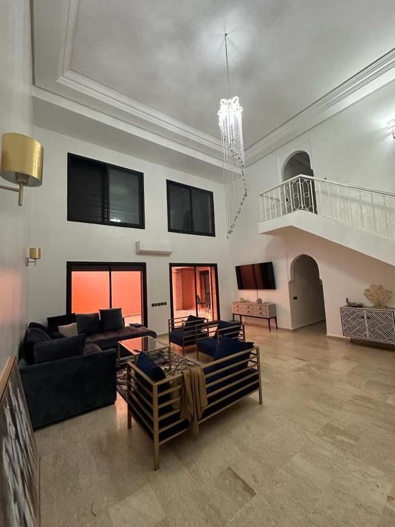 una gran sala de estar con sofás y una lámpara de araña. en Grand duplex idéal pour famille, en Marrakech
