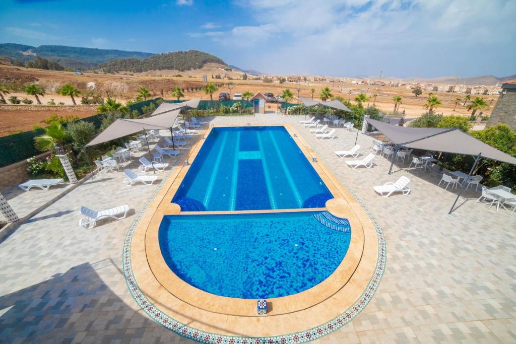 una vista sul soffitto di una piscina con sedie e ombrelloni di RIAD GOLD ad Azrou