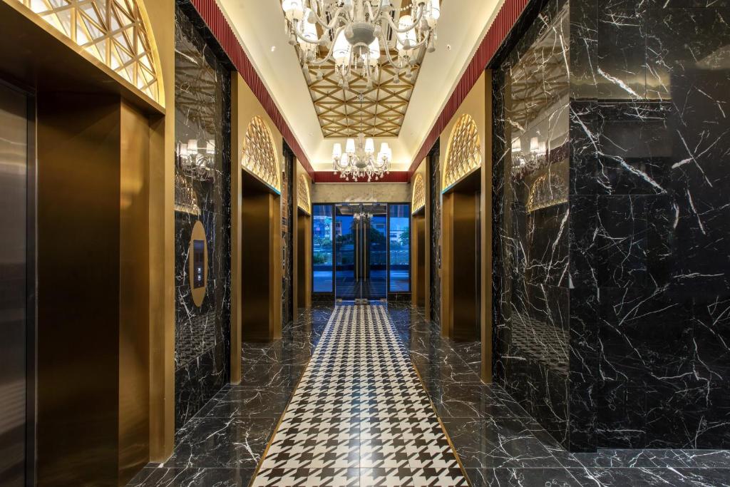 un corridoio con pareti in marmo nero e lampadario a braccio di NEW Insta Worthy B&W Designer Loft in Cheras, KL 