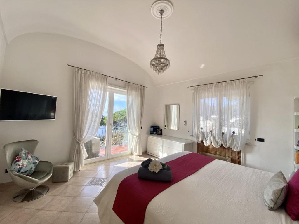 um quarto grande com uma cama grande e uma cadeira em MARVELOUS SEA VIEW VILLA em Capri