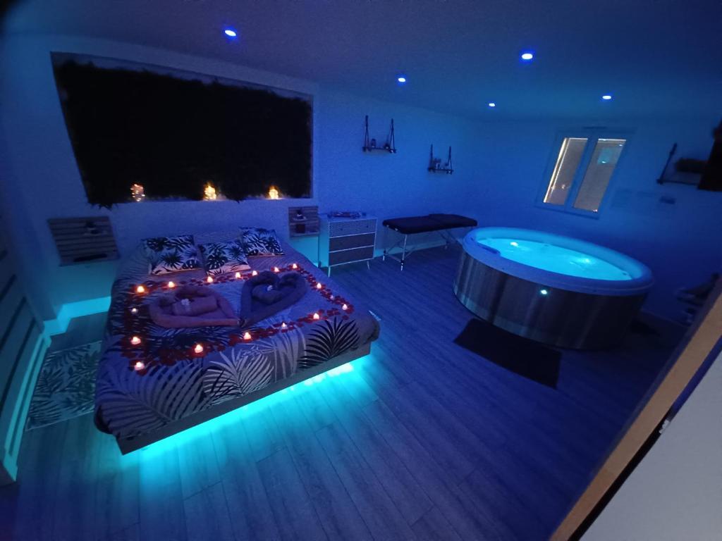 a blue room with a bed and a tub at Gîte et SPA Au Secret Du Bonheur in Pouilly-sur-Serre