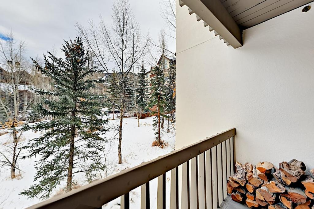 een balkon met een berg brandhout en sneeuw bij Townsend Place B206 in Beaver Creek