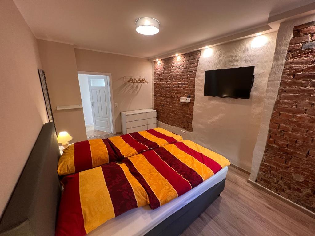 ein Schlafzimmer mit einem Bett und einer Ziegelwand in der Unterkunft Top Ferienwohnung, Zentrum, mit Garten, am Radweg in Bautzen