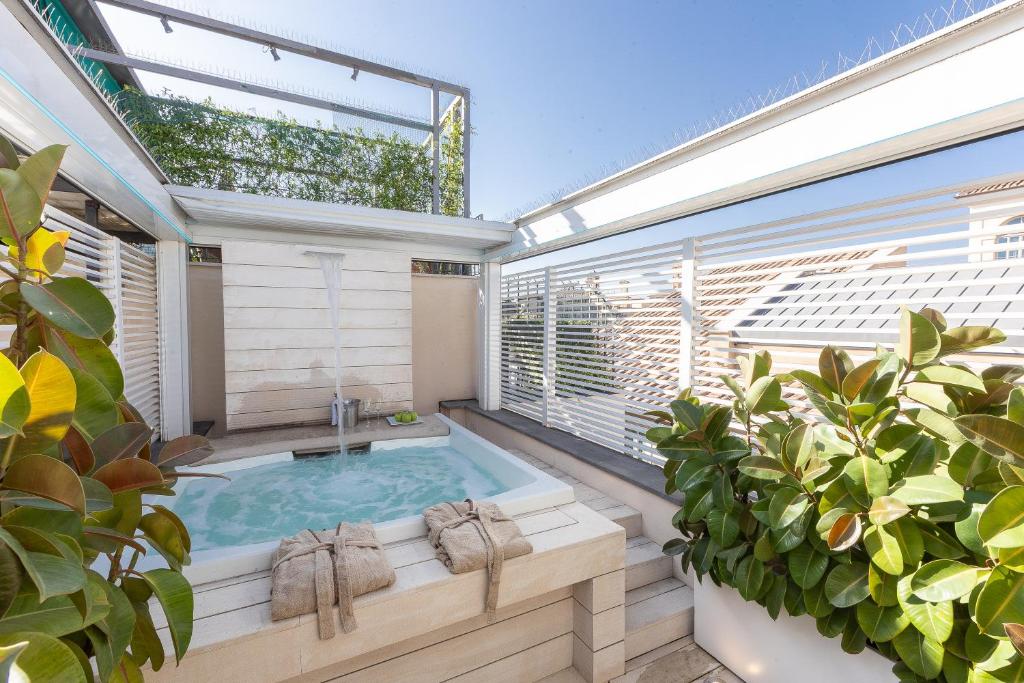 a hot tub on a balcony with plants at Amazing 3 Levels Penthouse Piazza Venezia in Rome