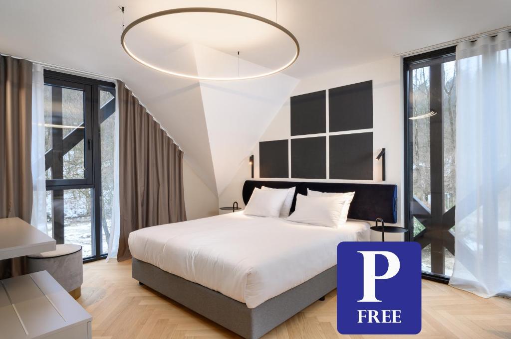 a bedroom with a large bed and a large chandelier at Hotel Čad in Ljubljana