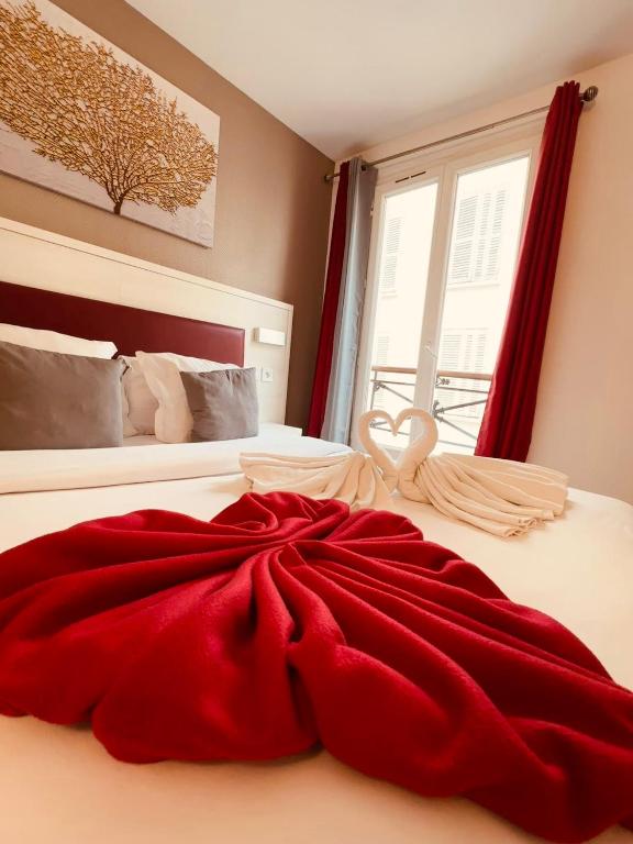 a red dress on a bed with a window at Pavillon Opéra Lafayette in Paris