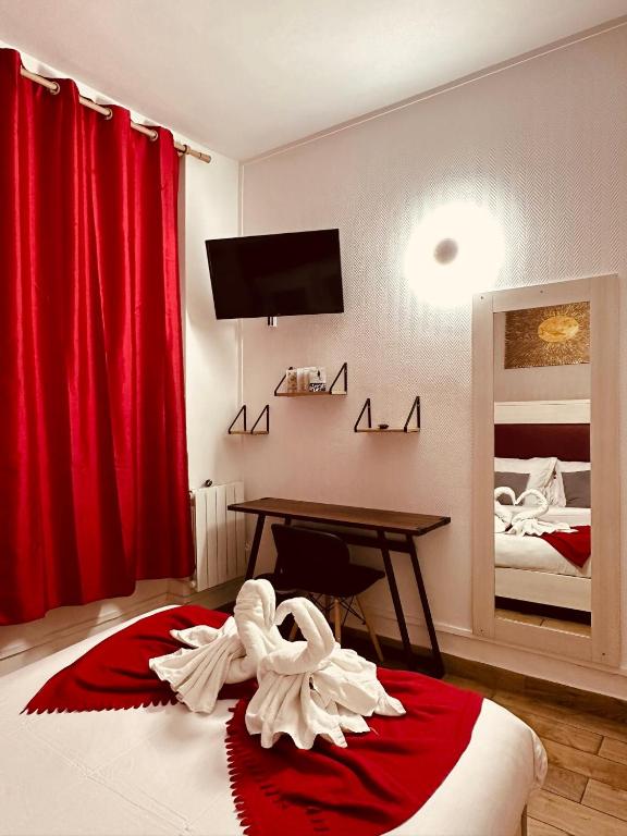 a bedroom with a bed with red curtains and a table at Pavillon Opéra Lafayette in Paris