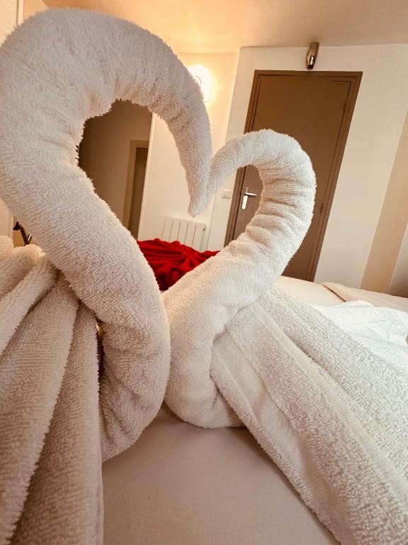 a pair of towels forming a heart on a bed at Pavillon Opéra Lafayette in Paris
