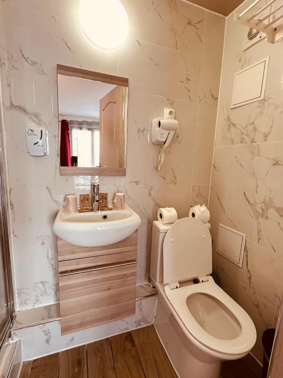 a bathroom with a toilet and a sink at Pavillon Opéra Lafayette in Paris