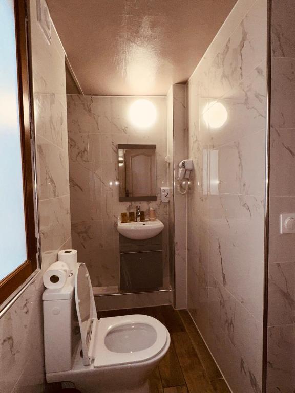 a small bathroom with a toilet and a sink at Pavillon Opéra Lafayette in Paris