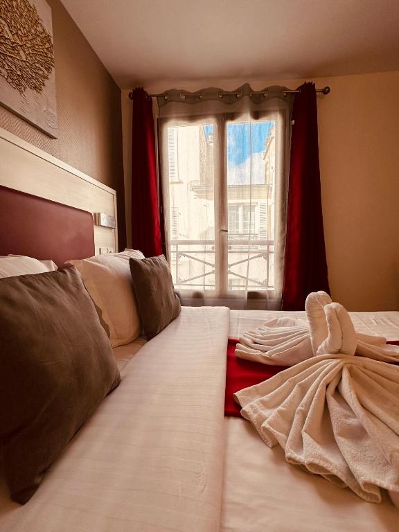 a bedroom with two beds and a window at Pavillon Opéra Lafayette in Paris