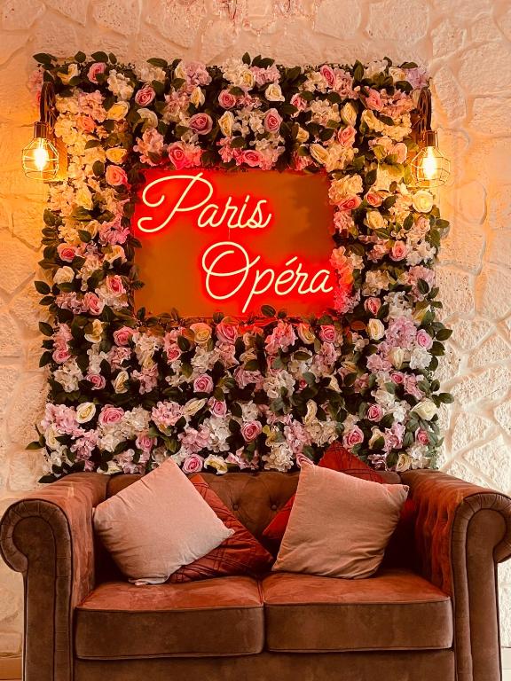a sign on a wall with flowers and a couch at Pavillon Opéra Lafayette in Paris