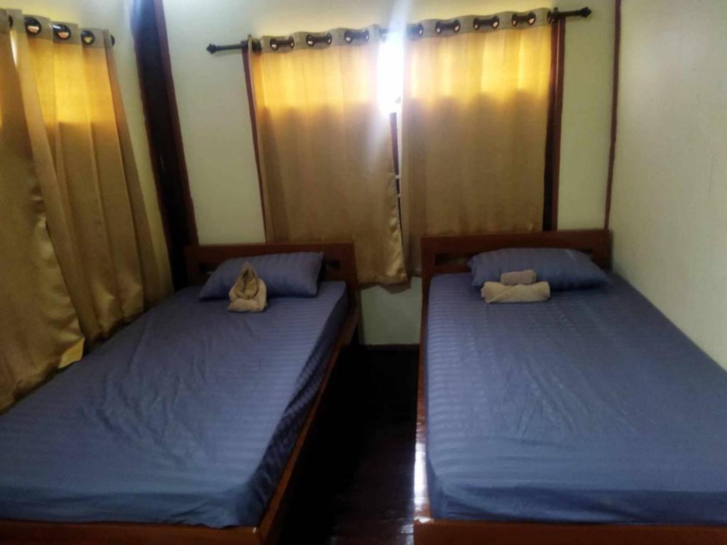 two beds in a room with blue sheets at BaanNakanoHomestay in Mae Rim