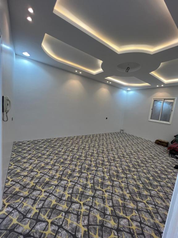 an empty room with white walls and a carpeted floor at شاليهات توليب in Sabt Alalayah